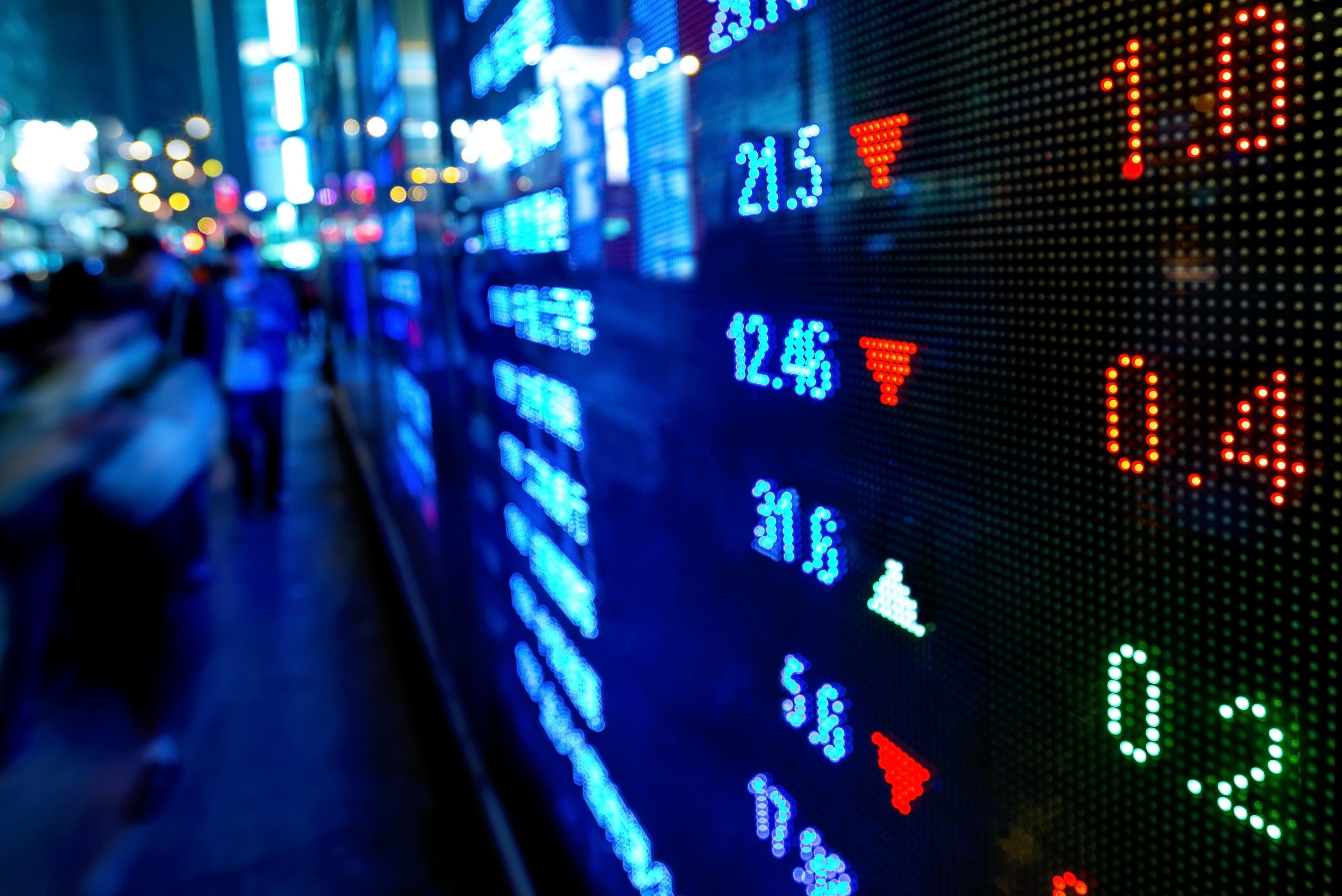 A close-up of a digital stock market ticker display showing live price movements