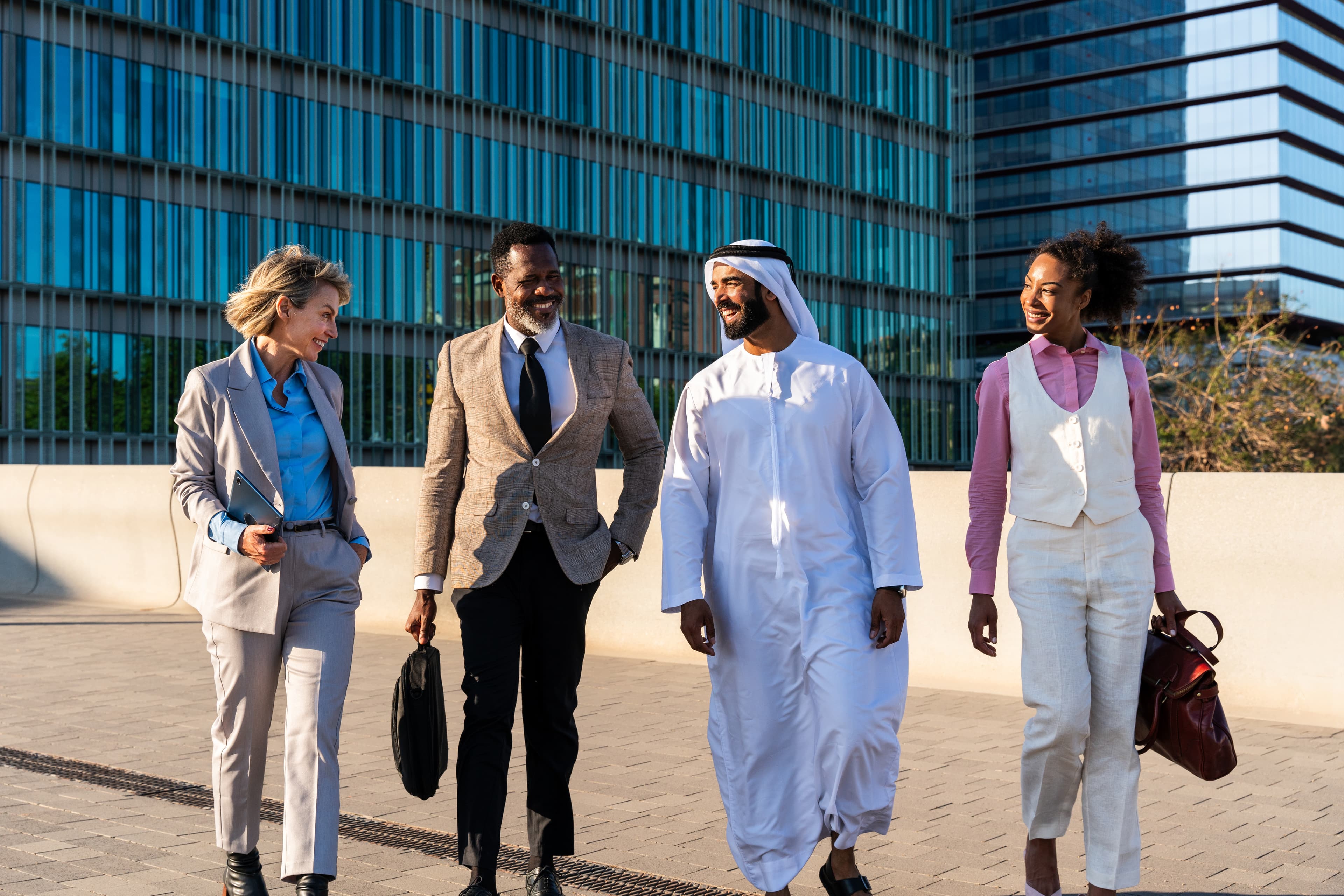 A diverse team of business professionals walking together outside a modern office building