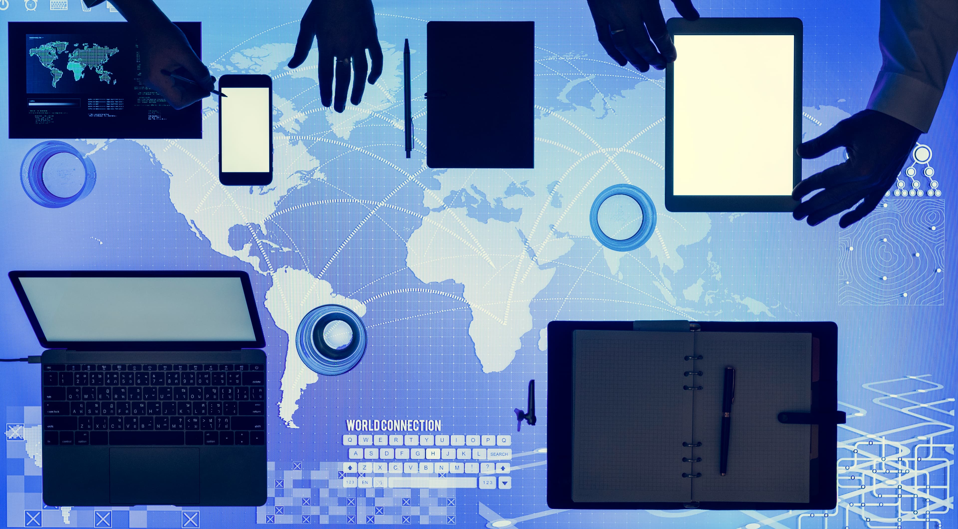 A global digital connection concept with devices laid out over a world map