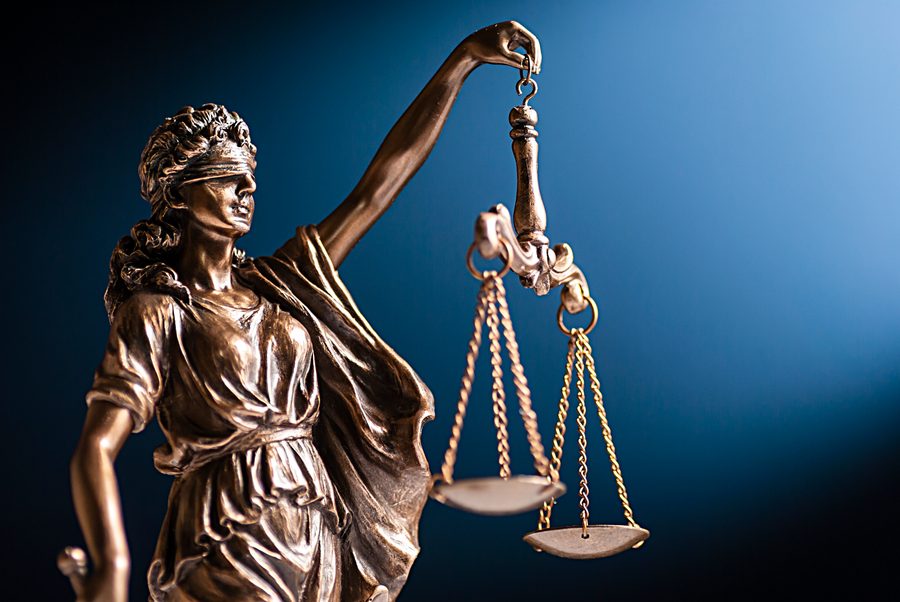 A blindfolded statue of Lady Justice holding the scales of justice